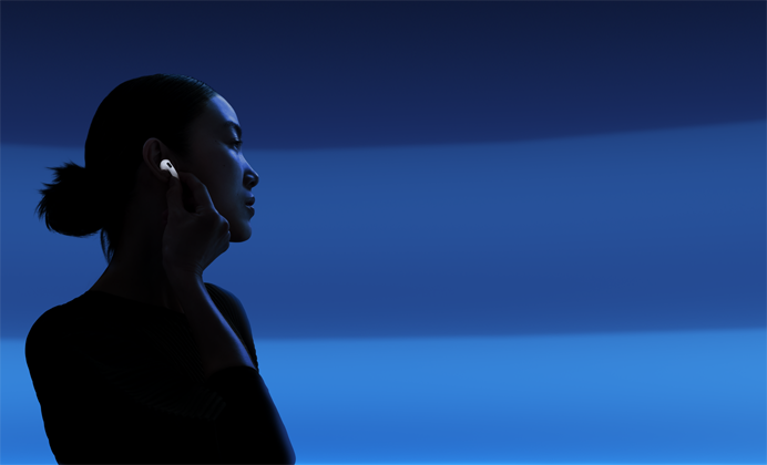 親指と人差し指でAirPods 5の軸部分をつまみ、リスニングモードを切り替えている人物