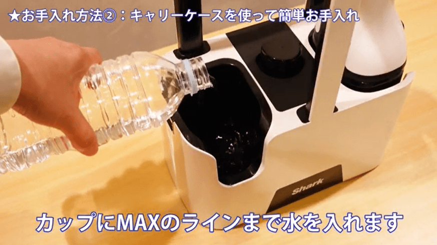キャリーケースのカップに水を注ぐ